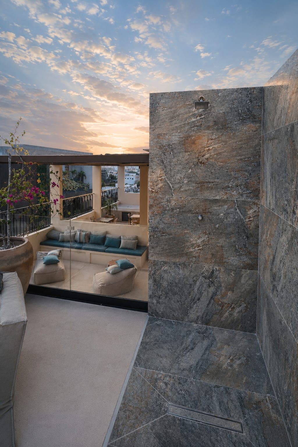 Regadera exterior del rooftop de Marbella, forrada en piedra, al atardecer