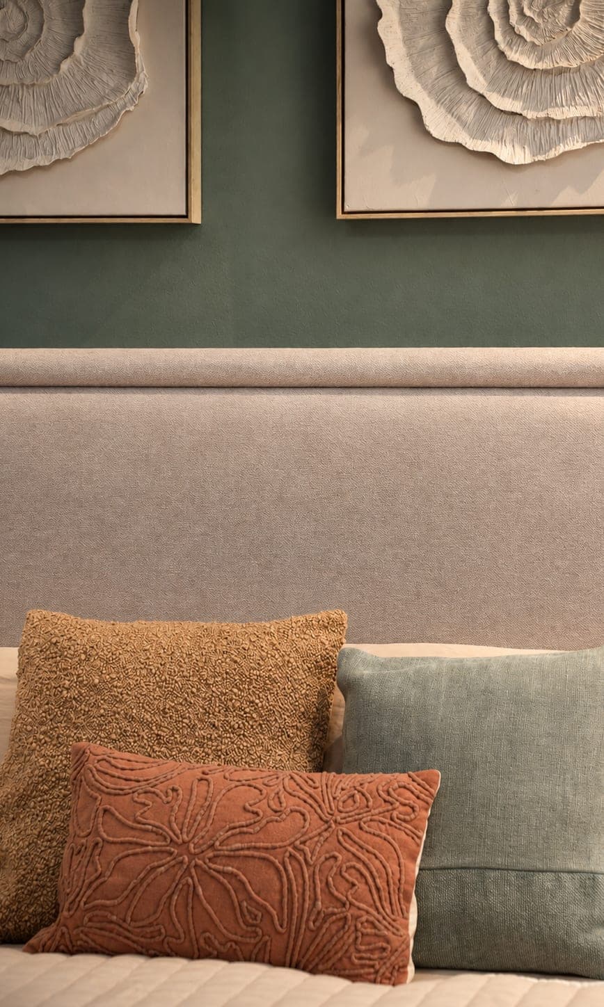 Headboard in a bedroom of the Edúlis penthouse, with the green wall, the shell reliefs and the cushions