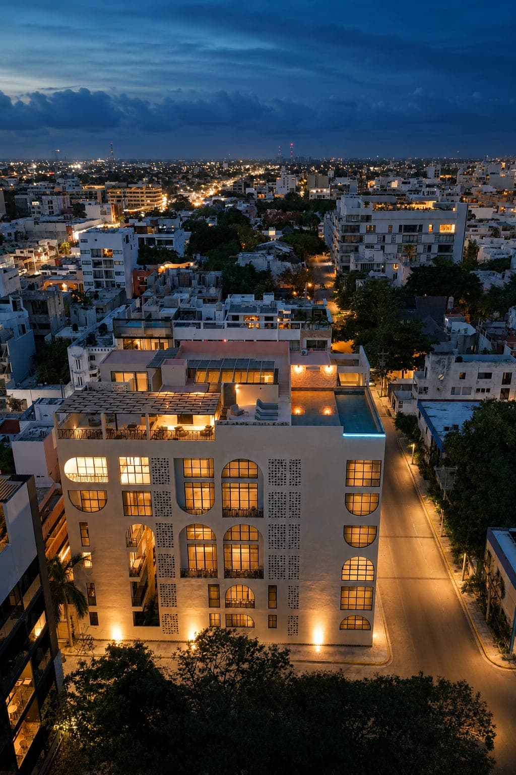 Marbella at dusk from the air, with the lit street and the city behind