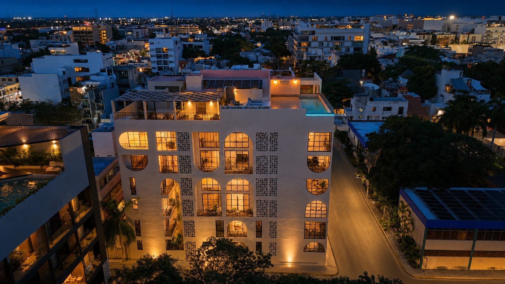 Marbella de noche desde el aire, con la fachada iluminada y la alberca del rooftop