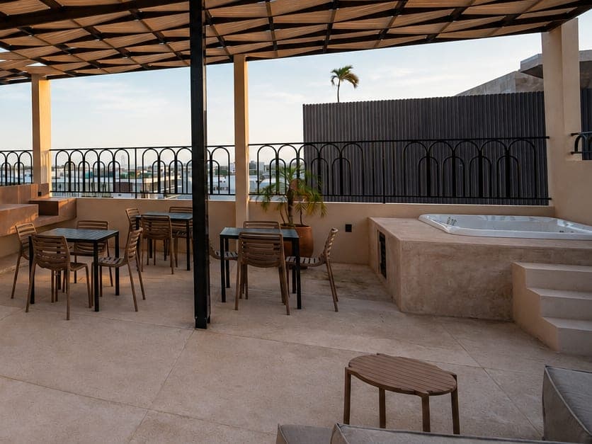 Tina de hidromasaje y mesas bajo la pérgola del rooftop de Marbella