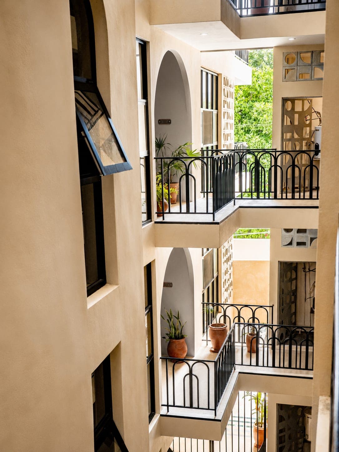 Balcones interiores con macetas de barro y entradas de arco