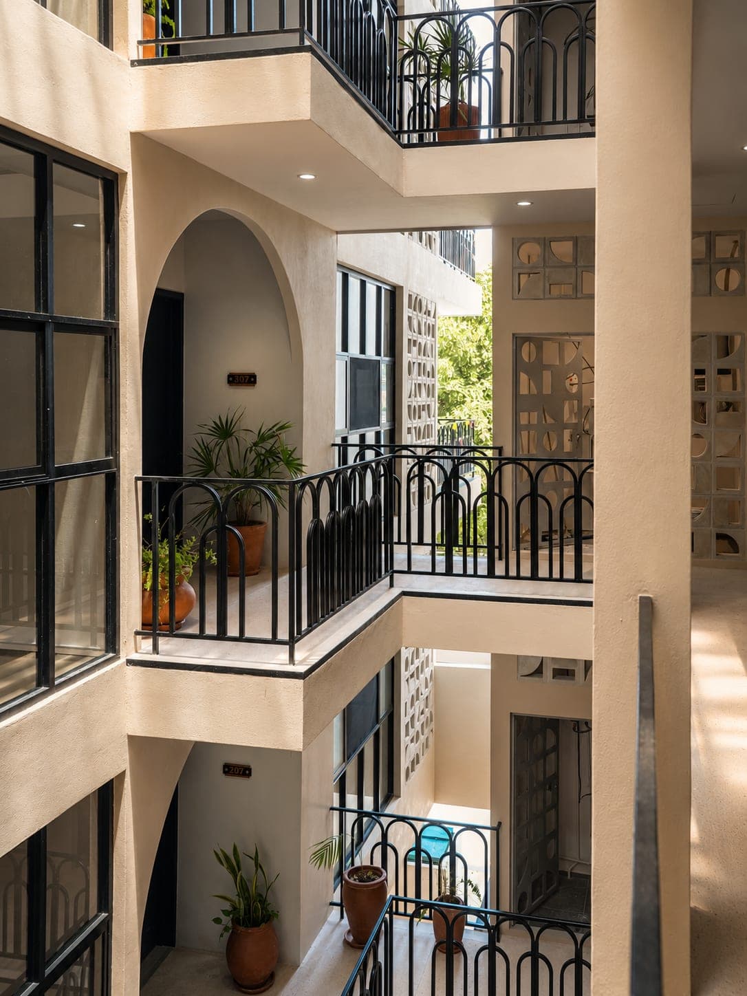 El patio interior desde arriba, con las puertas de las unidades y macetas en los pasillos
