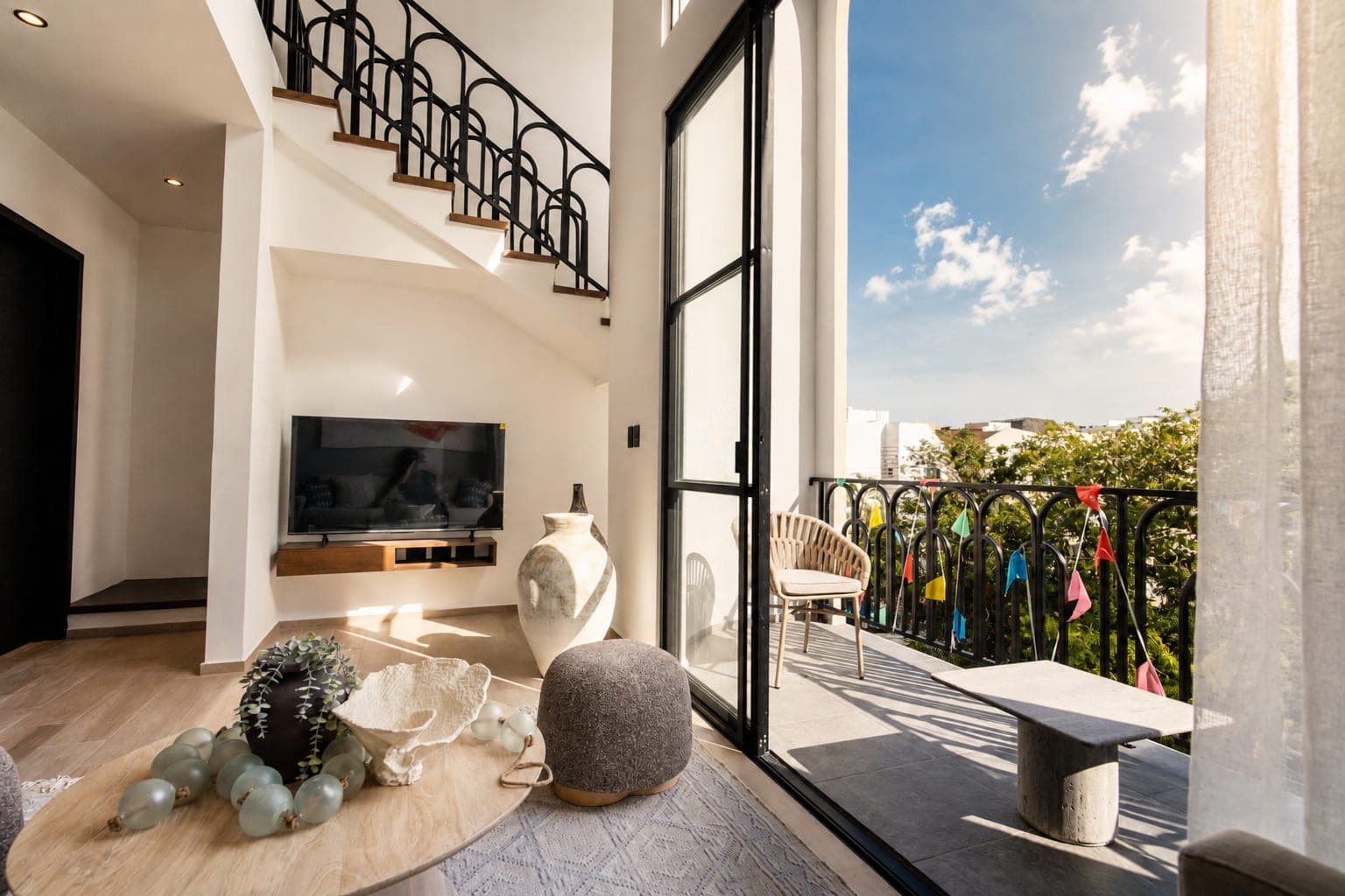 Sala del loft Strómbus en doble altura, con salida al balcón